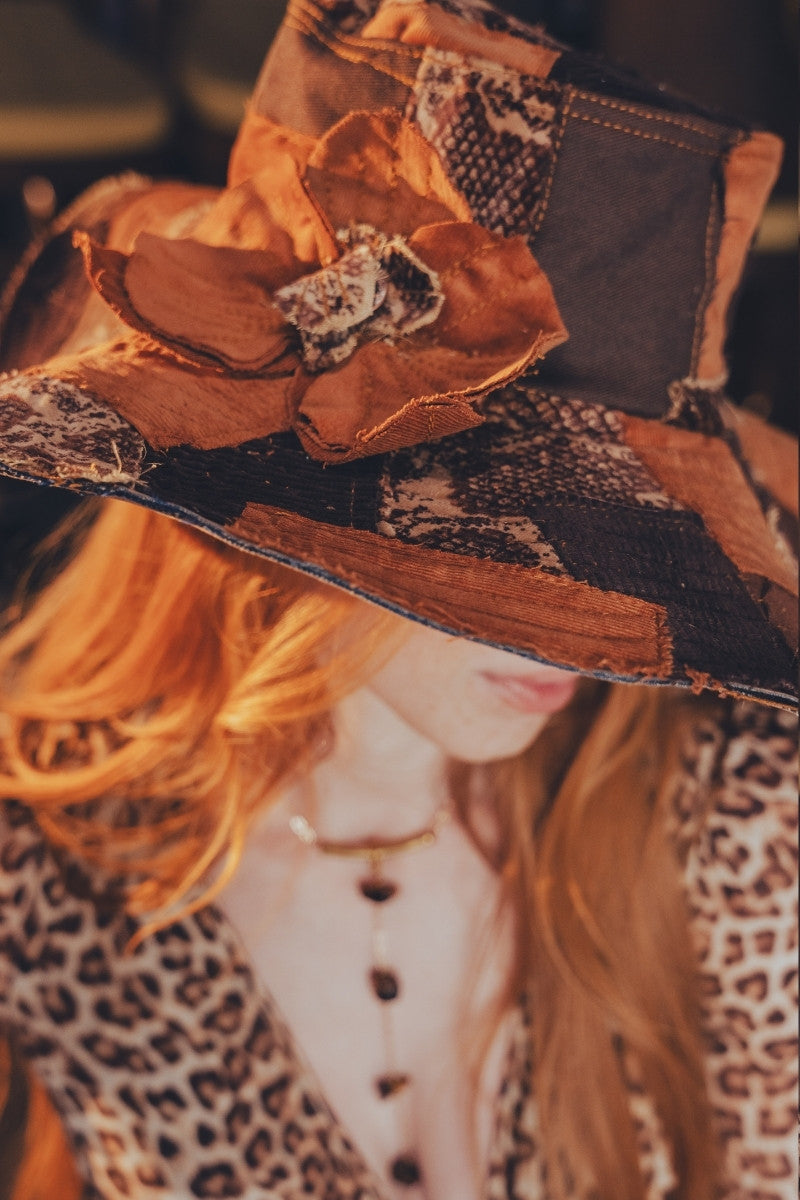 Close-up of a decorative hat with floral details and leopard print fabric.