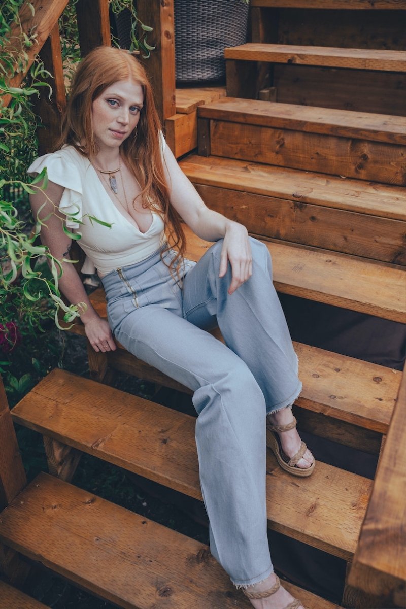 Woman sitting on wooden steps outdoors