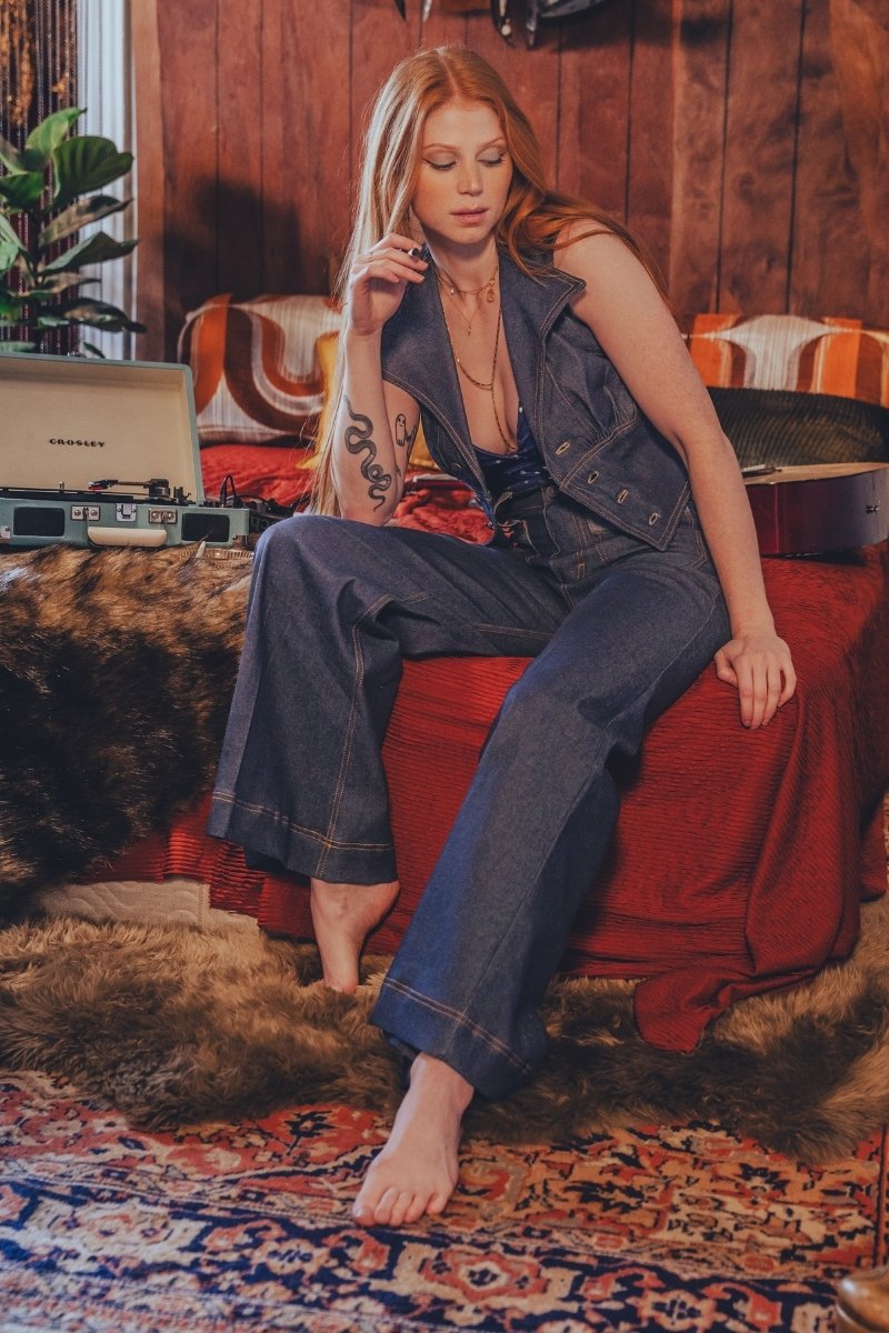 Woman sitting on a red couch in a cozy room with a vintage record player.