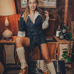1970s vibes shine as a woman wears a retro romper while spinning vinyl records in a throwback home setting