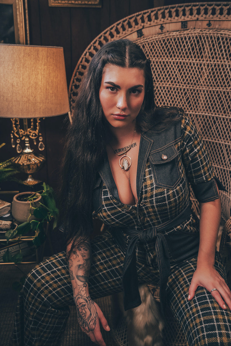 Knit plaid diva jumpsuit with contrasting denim front pockets, collar, and belt, blending retro 70's charm with bold, modern flair.