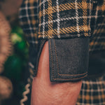 Knit plaid diva jumpsuit with contrasting denim front pockets, collar, and belt, blending retro 70's charm with bold, modern flair.