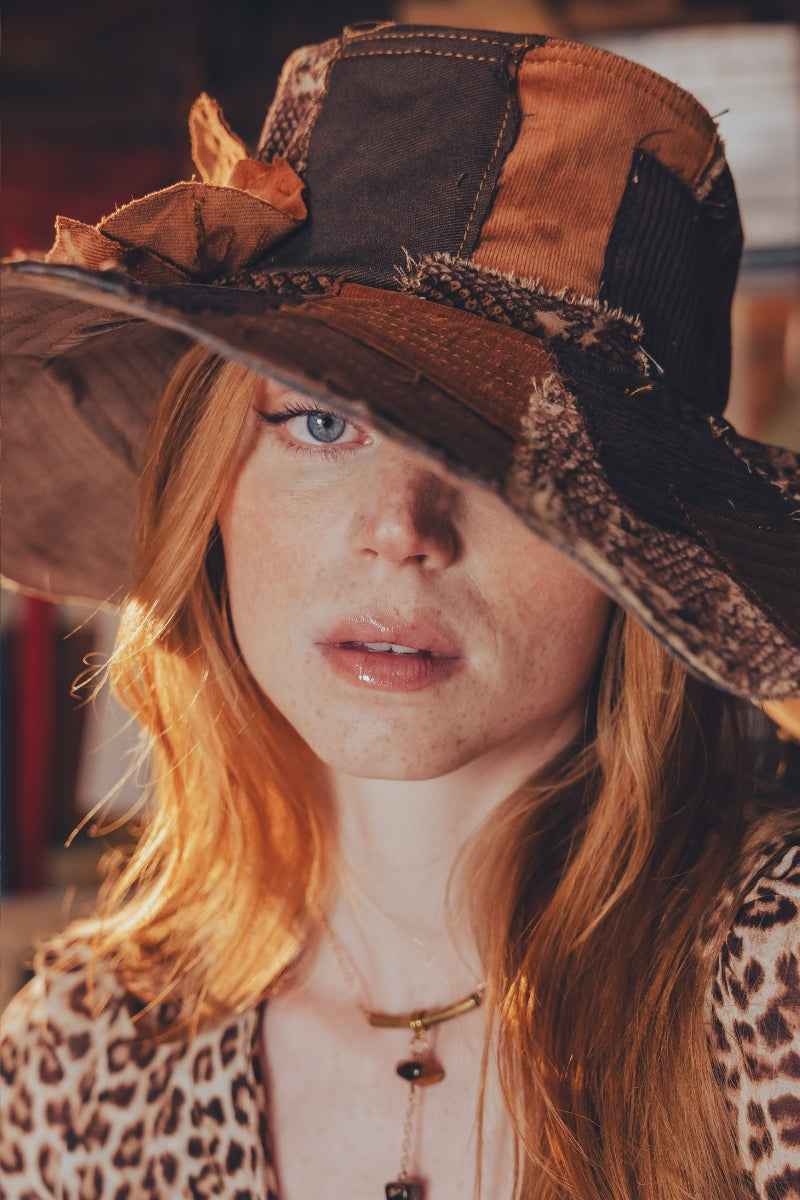 Person wearing a large, decorative hat with a leopard print pattern.