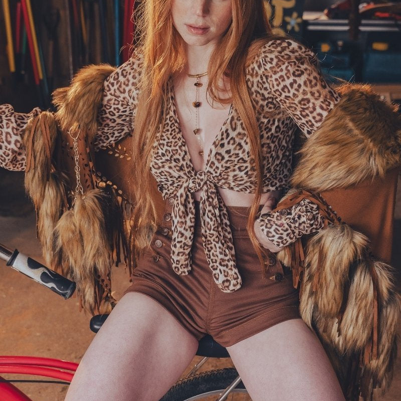 Model wearing chocolate Sally sailor shorts, a leopard-print tie-front top and a fur-trimmed jacket for a 70s-inspired festival outfit.