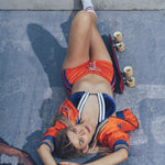 Soul Sister since 1969 orange retro bomber jacket on beauty blonde babe lying in a skateboard pool with her skateboard