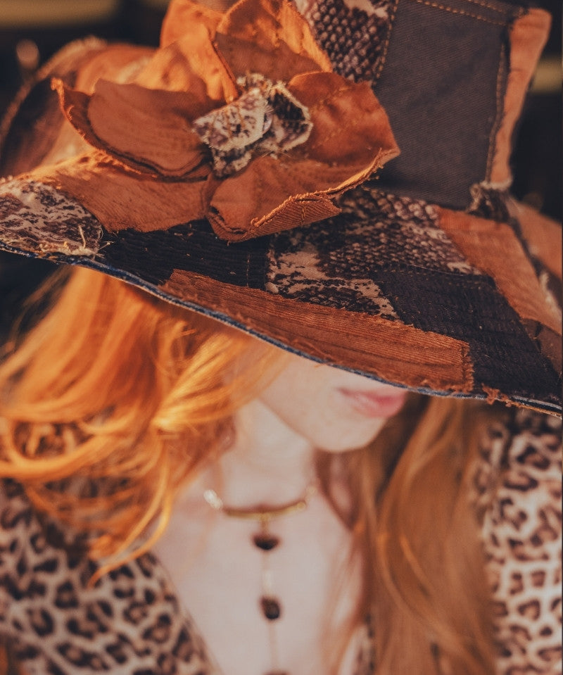 Close-up of a decorative hat with floral details and leopard print fabric.