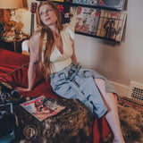 Woman sitting on a red couch in a room with vinyl records on the wall