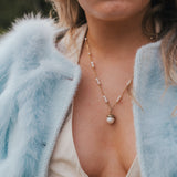 Close-up of a person wearing a light blue fur coat and pearl necklace. wearing Soul Sister since 1969