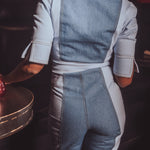 Person wearing a denim and white outfit in a dark setting