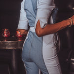 Person wearing a denim outfit in a dimly lit room with red lighting.