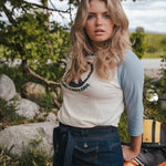 Woman standing outdoors with a scenic background Woman wearing a peace symbol shirt with text outdoors wearing Soul Sister since 1969