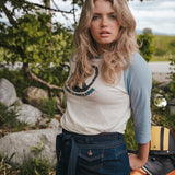 Woman standing outdoors with a scenic background Woman wearing a peace symbol shirt with text outdoors wearing Soul Sister since 1969
