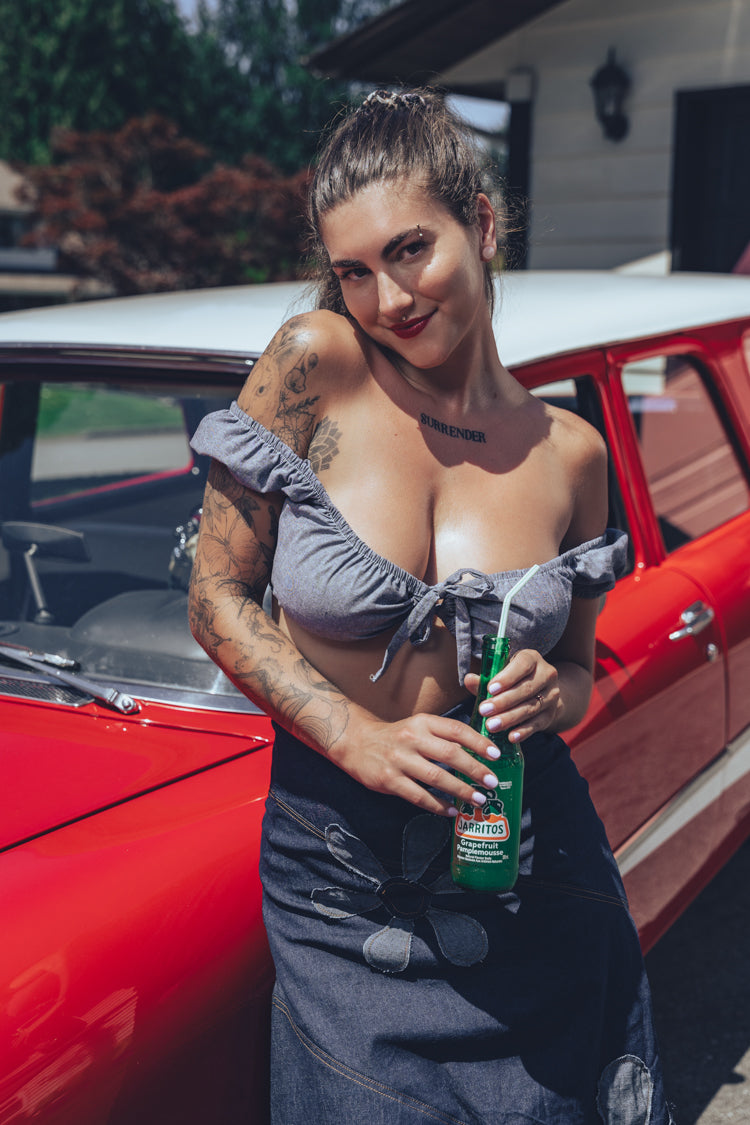 Soul Sisters Bridget Bardot crop top  and flower power skirt on model in front of red hot rod holding retro soda pop 