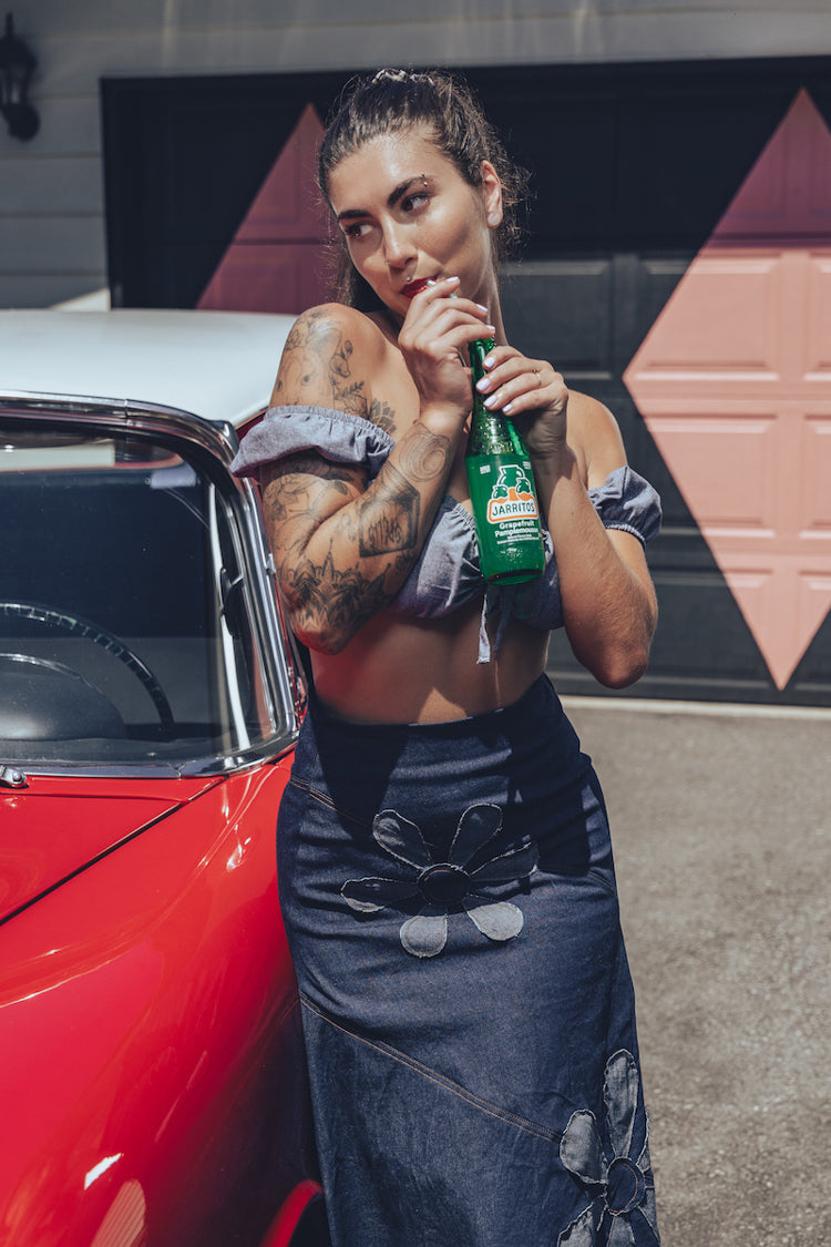 Soul Sisters Bridget Bardot crop top  and flower power skirt on model in front of retro hot rod