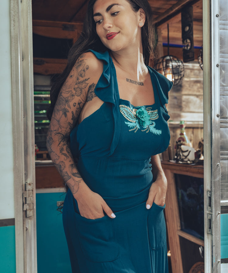 beautiful bohemian embroidered blue dress on woman in a retro trailer