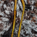 Gold chain necklace on a fur surface