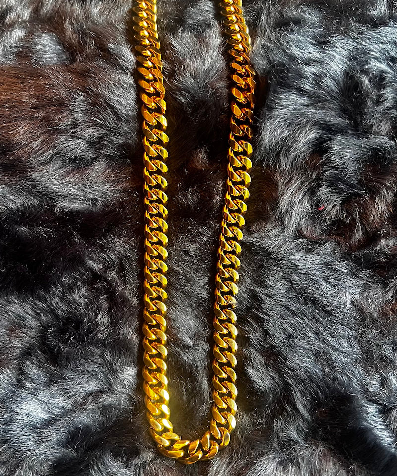 Gold chain necklace on a textured gray surface