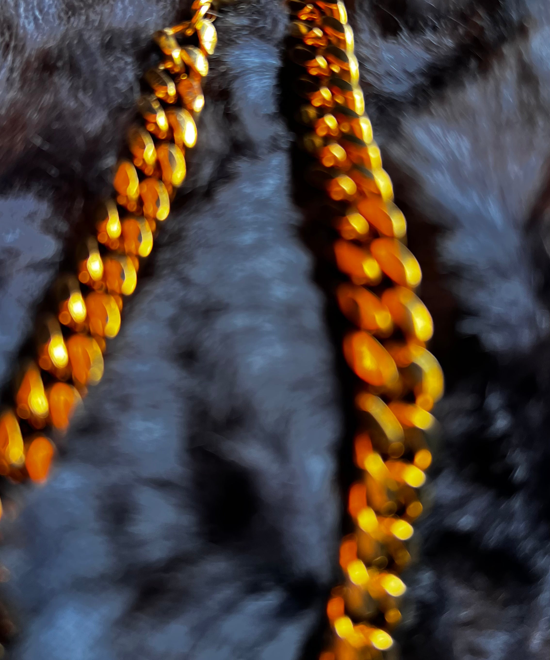 Gold chain necklace on a dark textured surface