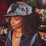 Woman wearing a denim cap with a flower accessory in a bar setting