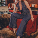 Woman sitting on a red couch in a cozy room with a vintage record player.