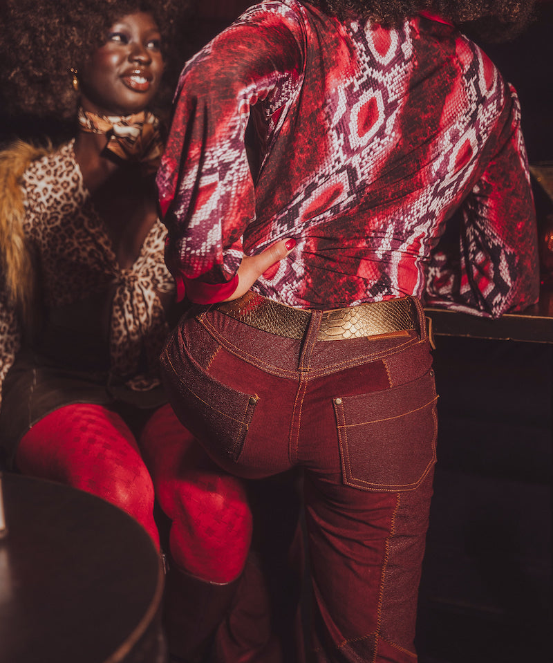 Person wearing a patterned red jacket and red pants with a blurred background