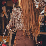 Woman with long blonde hair standing in a garage with a red bicycle.