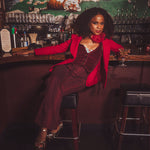 woman in a french nightclub wearing a red suit 70s style
