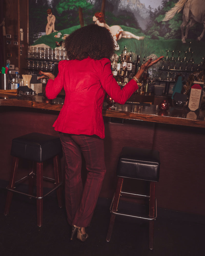 girl in a bar with her back turned wearing red
