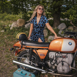 Woman in a blue dress standing next to a vintage BMW motorcycle in a natural setting wearing Soul Sister since 1969..
