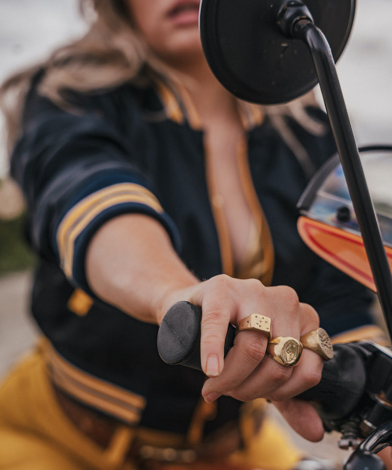 Person wearing gold rings on a motorcycle wearing Soul Sister since 1969 