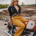 Woman sitting on a BMW motorcycle in an outdoor setting Soul Sister since 1969 