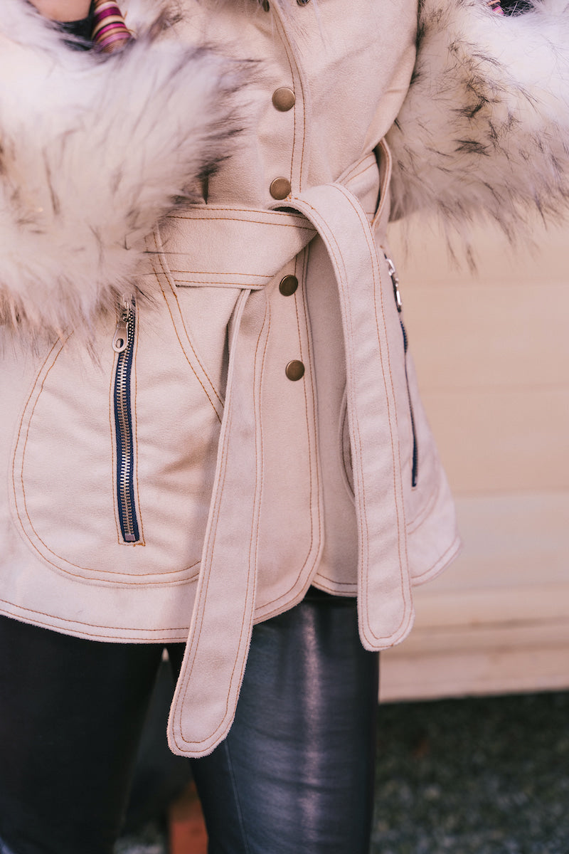 Close-up of a beige Penny lane vintage 70s inspired winter coat with fur  and belt