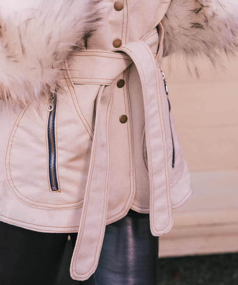 Close-up of a beige Penny lane vintage 70s inspired winter coat with fur  and belt