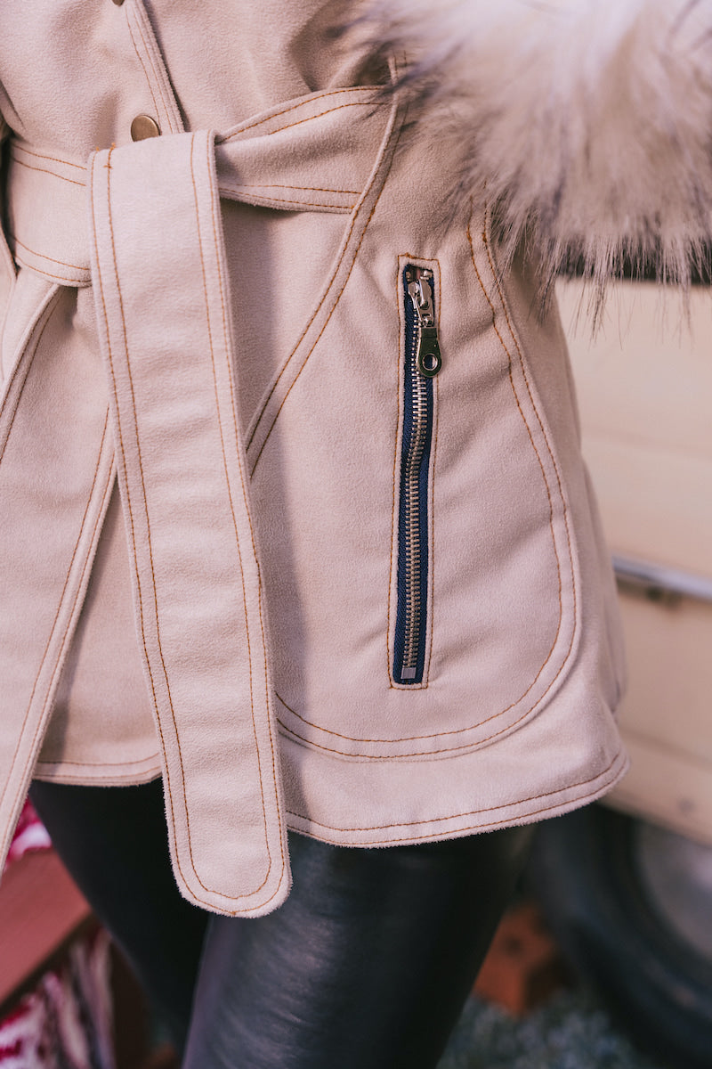 Close-up of a beige Penny Lane, 70s vintage inspired coat with fur trim and a zipper detail.