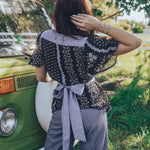 Girl wears floral to with bow at the back