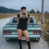 Woman posing in front of a vintage car on a rural road Ride or Die Motor Club wearing soul sister since 1969