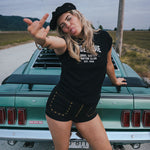 Woman posing in front of a vintage car on a road trip