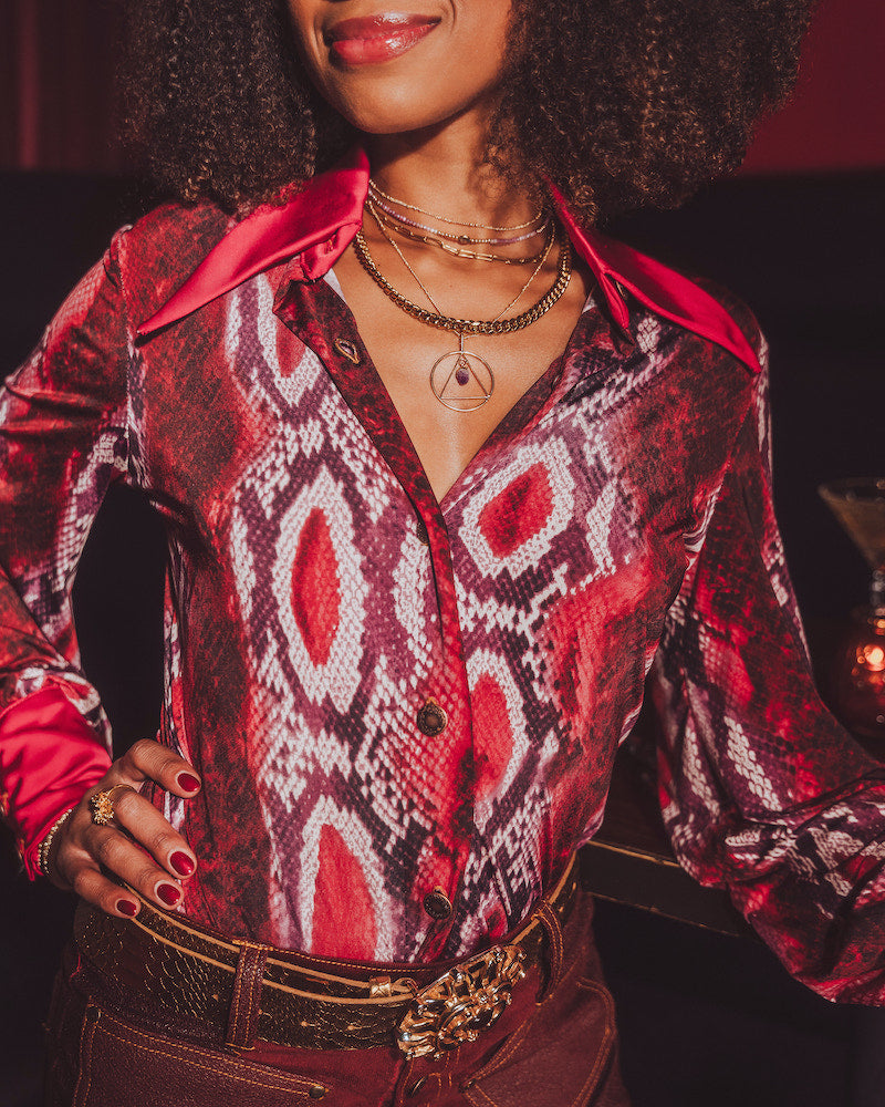 Person wearing a patterned red and black shirt with a blurred background