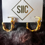 Gold hoop earrings on a card with 'SIIC' branding against a dark background