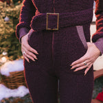 Person wearing a textured purple outfit with a belt in an outdoor setting.