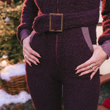 Person wearing a textured purple outfit with a belt in an outdoor setting.