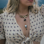 Woman wearing a floral blouse and a necklace with a butterfly pendant wearing Soul Sister since 1969.