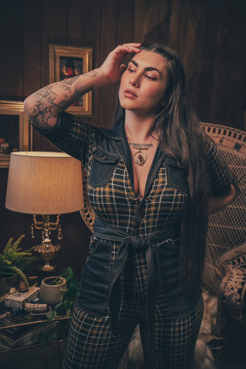 Knit plaid diva jumpsuit with contrasting denim front pockets, collar, and belt, blending retro 70's charm with bold, modern flair.
