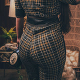Knit plaid diva jumpsuit with contrasting denim front pockets, collar, and belt, blending retro 70's charm with bold, modern flair.