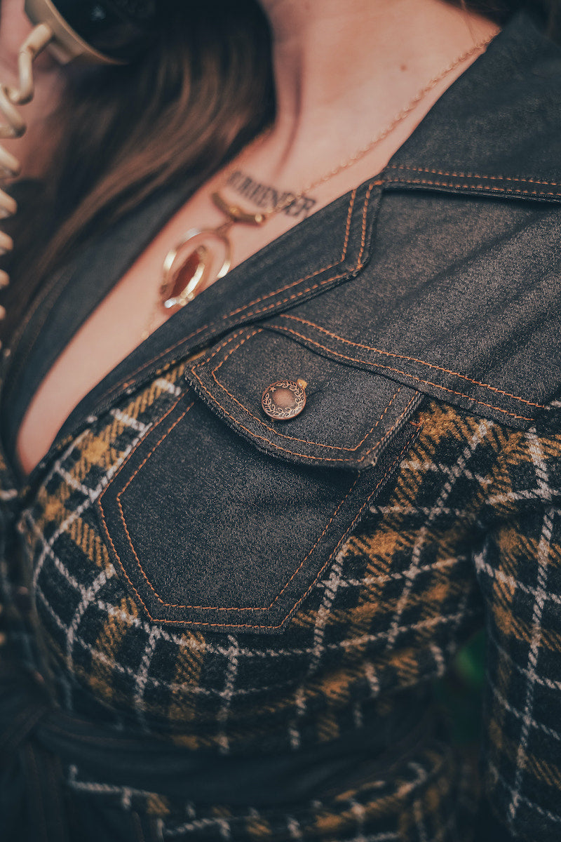 Knit plaid diva jumpsuit with contrasting denim front pockets, collar, and belt, blending retro 70's charm with bold, modern flair.