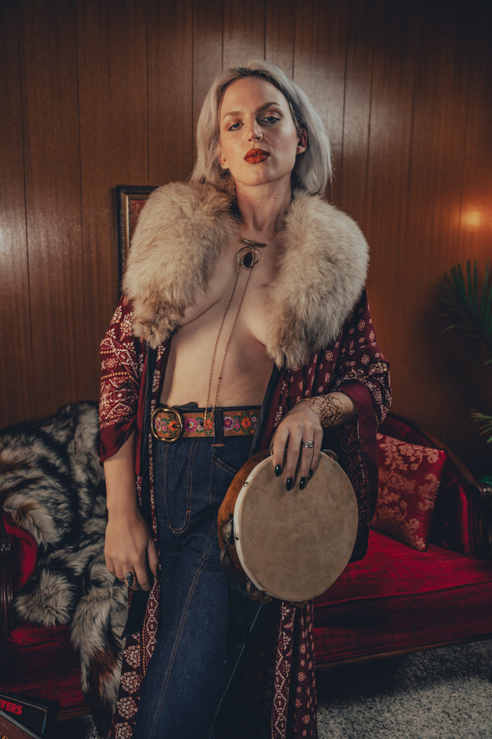 Beautiful woman wears bell bottom jeans in a 1970s retro living room
