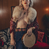 Beautiful woman wears bell bottom jeans in a 1970s retro living room

