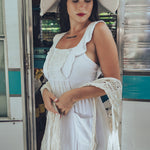 Soul Sister since 1969 long white dress on beautiful woman with a fringe shawl and retro floppy hat standing in a vintage trailer