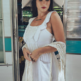 Soul Sister since 1969 long white dress on beautiful woman with a fringe shawl and retro floppy hat standing in a vintage trailer