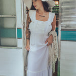 Soul Sister since 1969 long white dress on beautiful woman with a fringe shawl and retro floppy hat standing in a vintage trailer